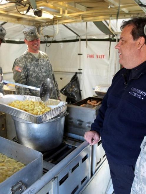 New Jersey Governor (C) Chris Christie talks with New Jersey National Guard cooks while they...