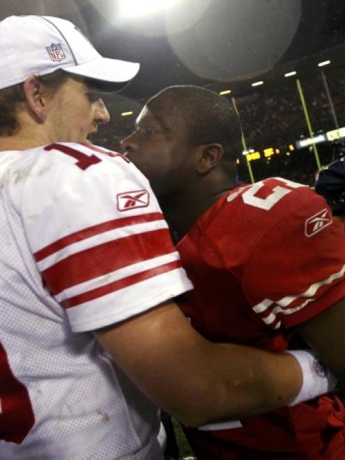 New York Giants quarterback Eli Manning (L), is congratulated by San Francisco 49ers running back...