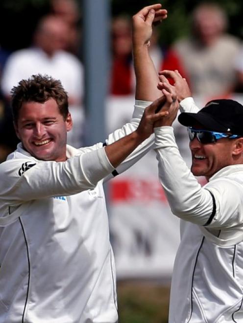 New Zealand captain Brendon McCullum (R) congratulates teammate Bruce Martin after the latter...