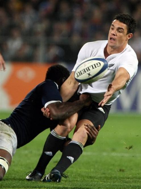 New Zealand's Dan Carter is tackled by France's Fulgence Ouedraogo. (AP Photo/Claude Paris)