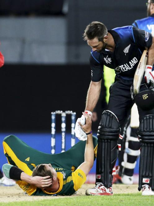New Zealand's Grant Elliot (R) helps South Africa's bowler Dale Steyn up after New Zealand won...
