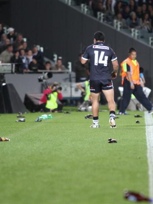 New Zealand's Issac Luke kicks bottles thrown onto the pitch by the crowd during the rugby league...