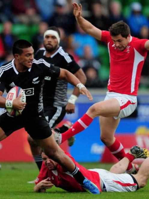 New Zealand's Lote Raikabula slips the tackle of Wales' Tom Grabham of Wales during their match...
