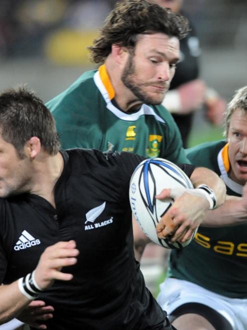 New Zealand's Richie McCaw slips the tackle of South Africa's Danie Rossouw in the International...