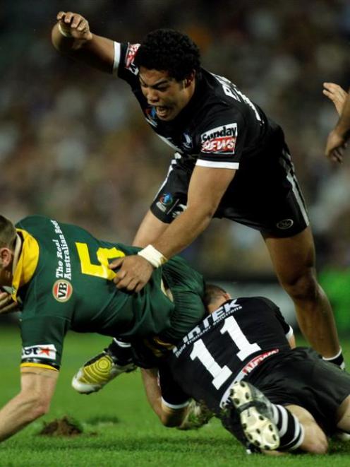 New Zealand's Simon Mannering, right, and Adam Blair, top, tackle Australia's Brent Tate during...