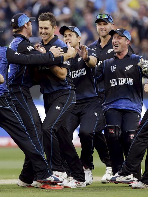 New Zealand's Trent Boult (C) is surrounded by team mates as they celebrate dismissing Australia...