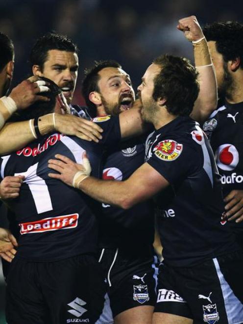 New Zealand Warriors halfback Nathan Fien (centre) celebrates with team-mates after scoring a try...