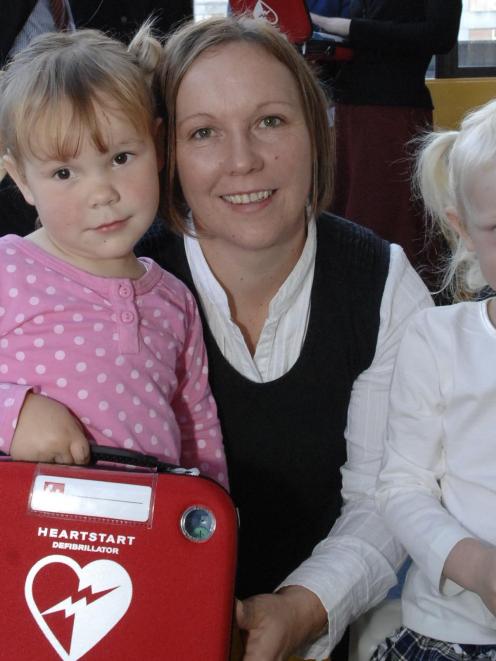 Nicci Reddy with daughters Caitlin (left) and Madison Frost with the "Heartstart" defibrillator...