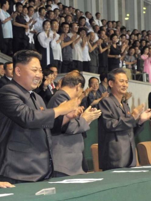 North Korea leader Kim Jong-un (L) applauds during the final of the Torch Cup football tournament...