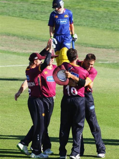 Northern Districts players celebrate winning the one-day final while a dejected Otago...