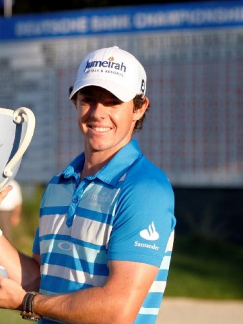 Northern Ireland golfer Rory McIlroy holds up the championship cup after winning the Deutsche...