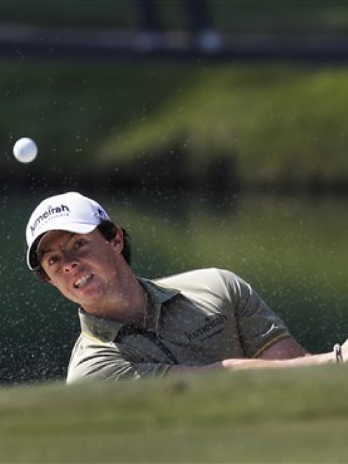 Northern Ireland's Rory McIlroy blasts out of a bunker on the second hole on the way to winning...