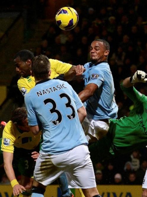 Norwich City players force a save by Manchester City's goalkeeper Joe Hart (3rd R) during their...