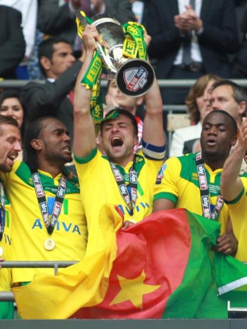 Norwich City's Russell Martin lifts the trophy as the team celebrate their promotion to the...
