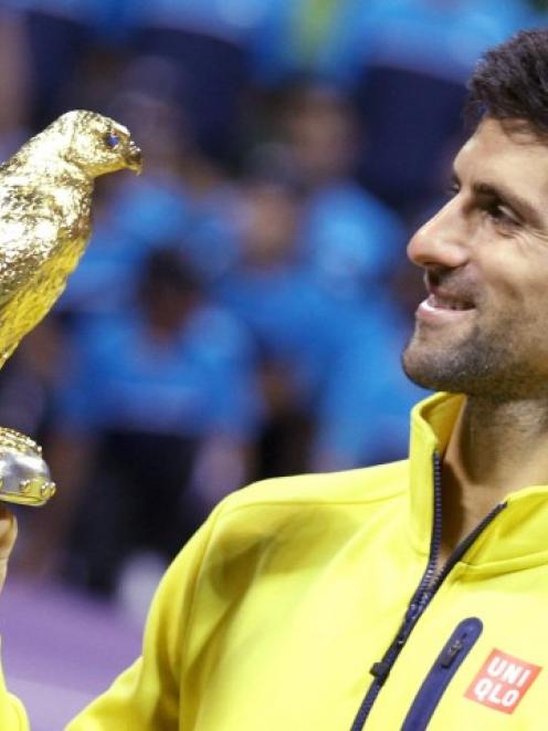 Novak Djokovic holds the trophy after winning the Qatar Open. REUTERS/Naseem Zeitoon