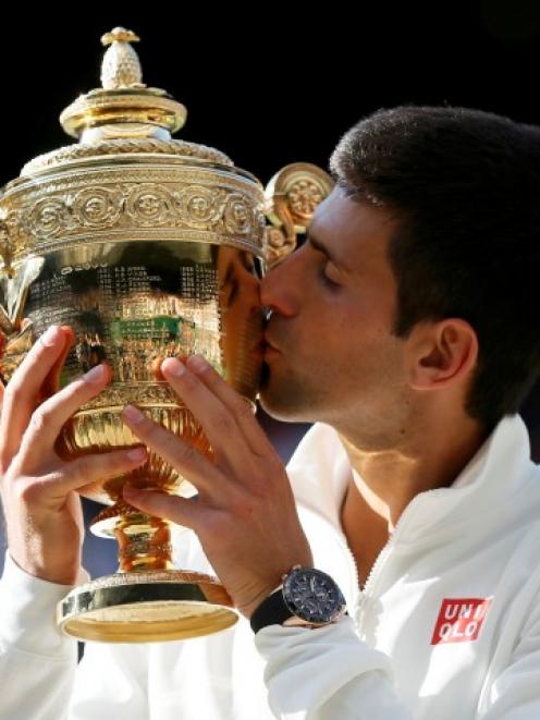 Novak Djokovic kisses the trophy after beating Roger Federer in their men's singles final at...