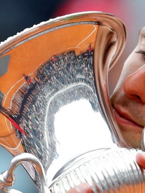 Novak Djokovic kisses the trophy after winning the Italian Open final against Rafael Nadal....