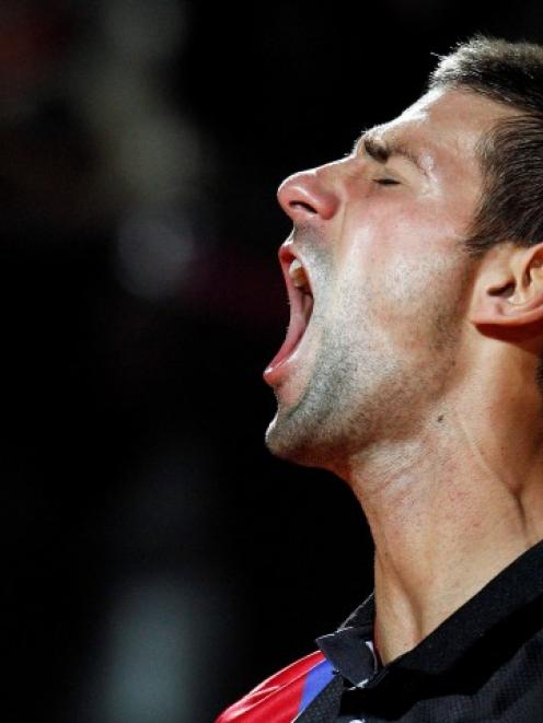 Novak Djokovic of Serbia celebrates after winning his semifinal match against Roger Federer of...