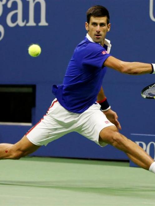 Novak Djokovic plays a shot in his tenth grand slam victory, where he beat Roger Federer in four...