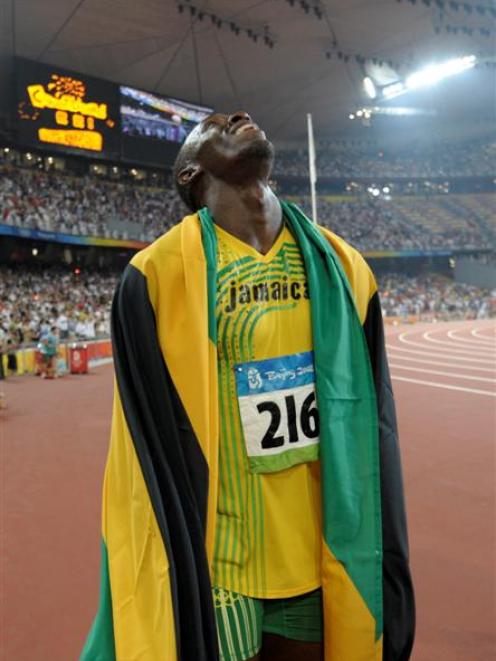 Nugget-fan Usain Bolt celebrates winning the gold and setting a new world record in the men's...