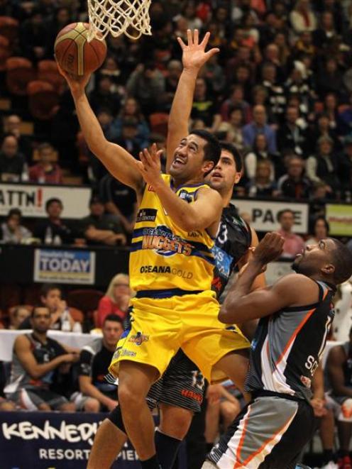 Nuggets point guard Micah Lepaio finds a gap between two Hawks defenders as he drives to the...