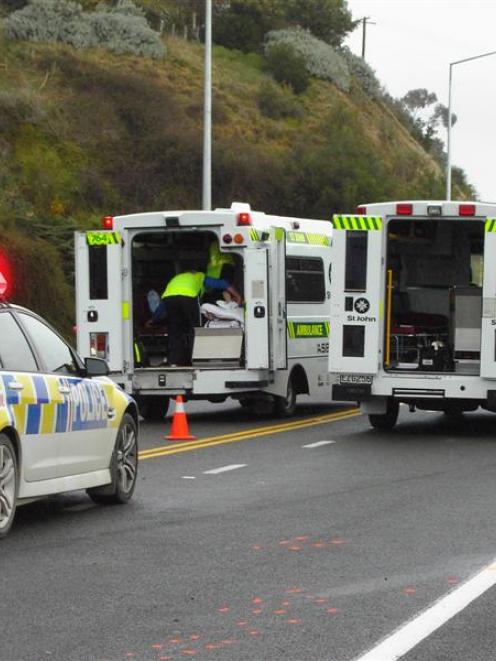 Oamaru Ambulance officers treat a motorcyclist in an ambulance (centre) for serious injuries he...