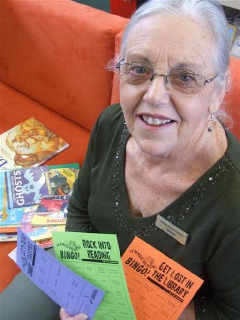 Oamaru Public Library youth librarian Alison Sofield holds book bingo cards for the competition...