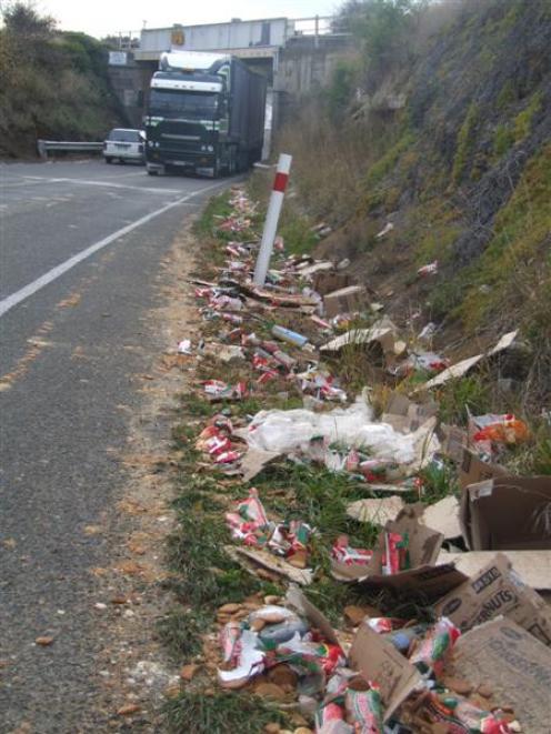 Packets of biscuits lie strewn along State Highway 1 by the Deborah overbridge yesterday...