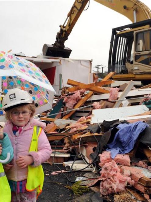 Observing the demolition of Green Island Kindergarten yesterday are Hannah Jones (4, left) and...