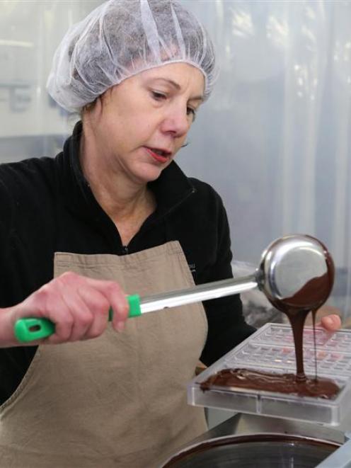 Ocho chocolate maker Liz Rowe pours chocolate into a mould. Photo by Craig Baxter.