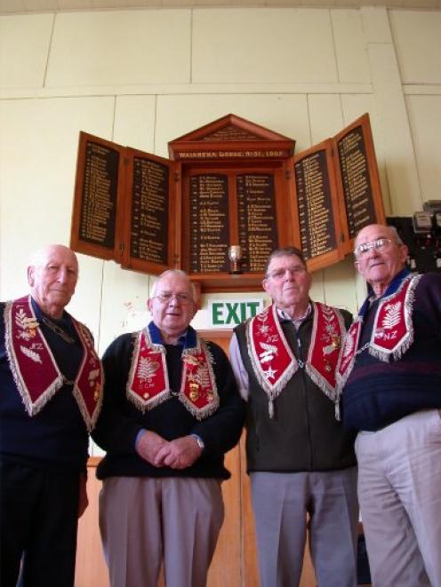 Long-serving members of IOOF Waiareka Lodge No 51 gather below the lodge's honours board at the...