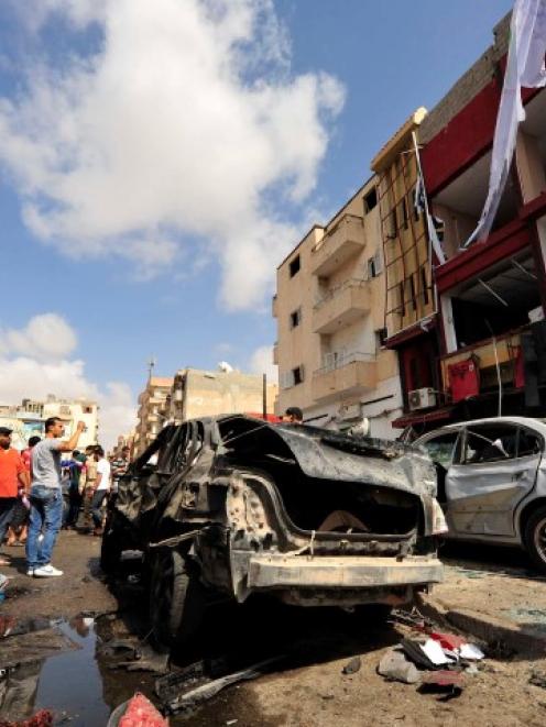 Onlookers take photographs following a car bomb explosion outside a hospital in Benghazi, Libya....