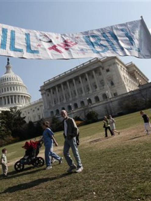 Opponents of the health care reform bill carry a "Kill the Bill" sign as protesters begin to...