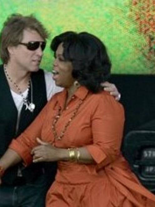 Oprah Winfrey holds hands with singer Jon Bon Jovi on stage during the filming of Oprah's...