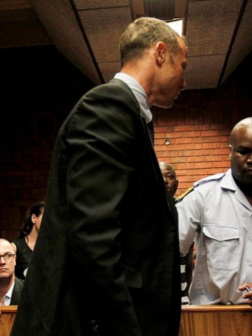 Oscar Pistorius (C) is escorted by police during a court appearance in Pretoria on Friday....