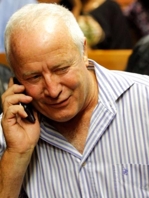 Oscar Pistorius's father Henke speaks on a mobile phone at the Pretoria Magistrates court during...