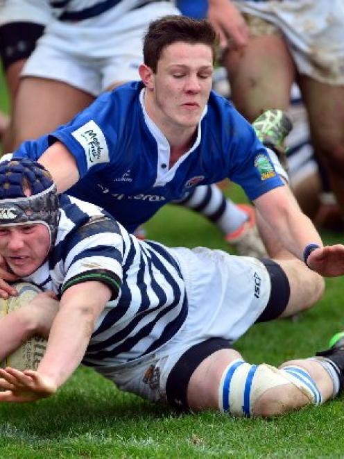 Otago Boys' High School flanker Riley McDowall scores a try despite the attentions of Southland...