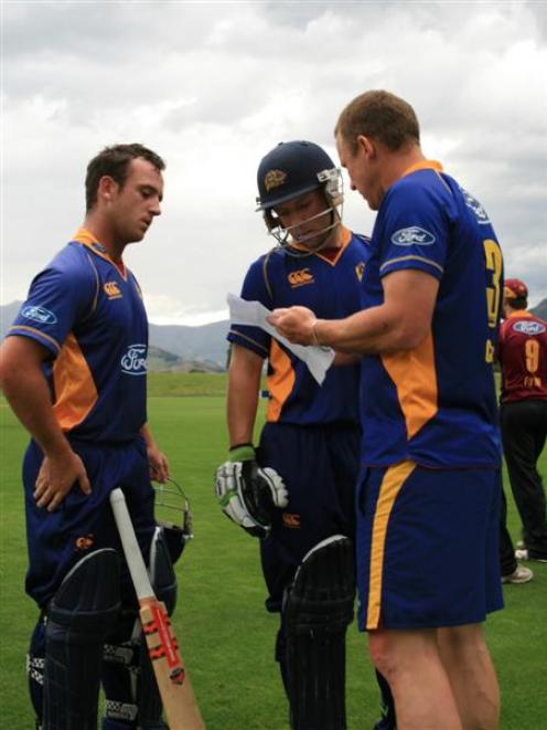 Otago captain Craig Cumming shows Darren Broom (left) and Derek de Boorder the Duckworth-Lewis...
