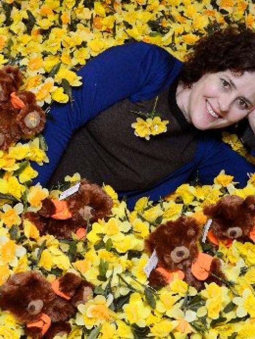Otago Daffodil Day co-ordinator Gwen Macready lies among the fake daffodils and toy bears to be...