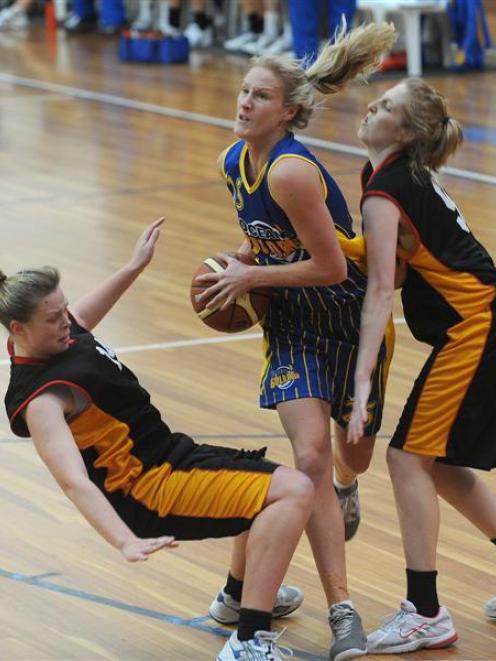 Otago Goldrush forward Patrice McKenzie (centre) powers her way between Waikato's Miriam Slatter ...