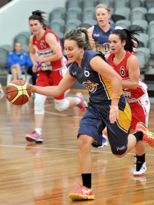 Otago Goldrush player Janet Main makes her way down the court with the ball. She is followed by...