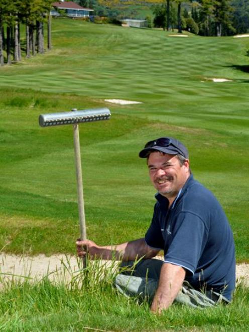 Otago Golf Club golf course manager Craig Parata takes a break from smoothing the sand in a...