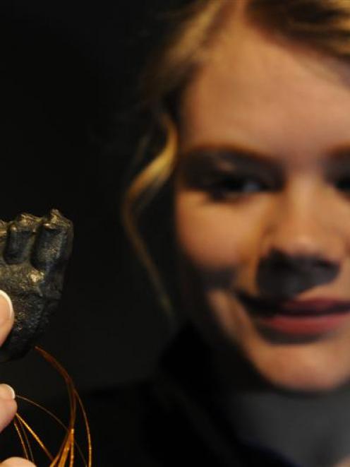 Otago Museum shop communicator Sarah Harkness  displays a grey polished steel 3-D printed giraffe...