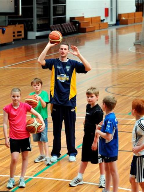 Otago Nugget Luke Aston passes on some shooting tips to members of the Diggers junior basketball...