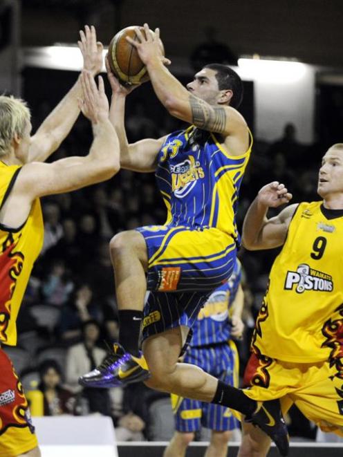Otago Nuggets guard Sam To'omata glides to the hoop past Waikato Pistons defenders Tony Ronaldson...