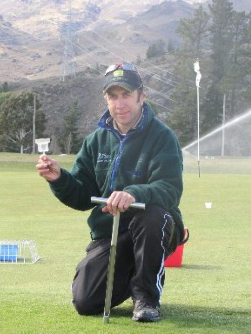 Otago polytechnic sports turf management project manager Gary Smith holds one of the plastic cups...
