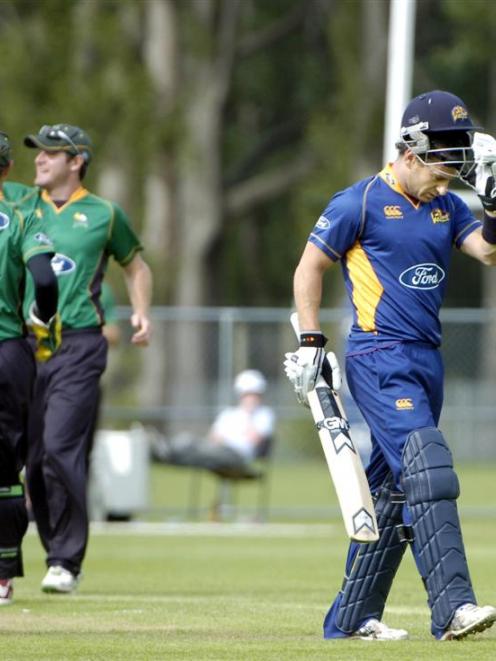 Otago's Nathan McCullum walks off as Central players celebrate his dismissal. Photo by Jane Dawber.