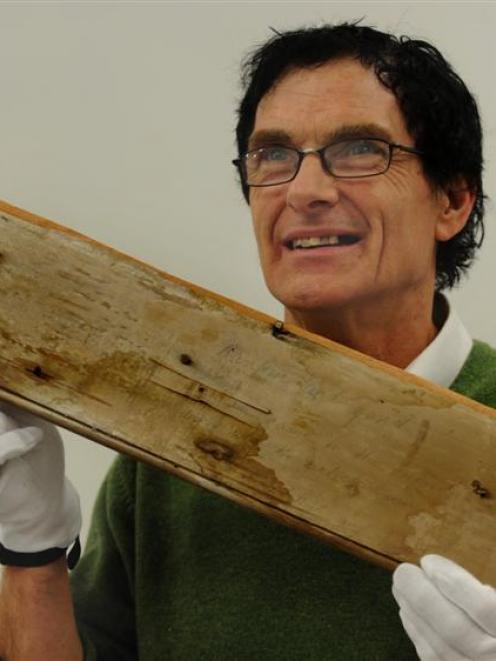 Otago Settlers Museum assistant conservator Laurence Le Ber with a  piece of graffiti from an...