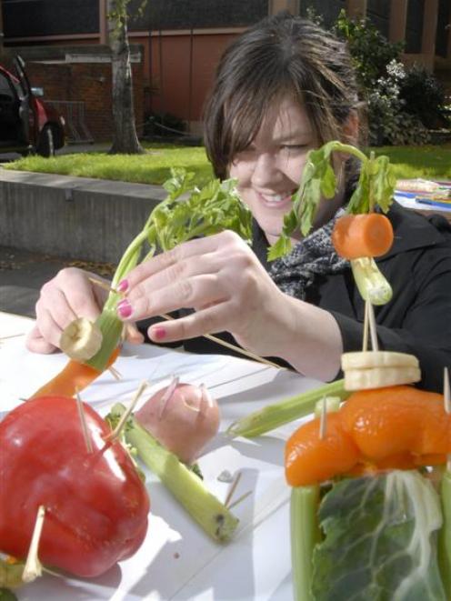 Otago University Students Association assistant events manager Sarah Comer adjusts vegetable...