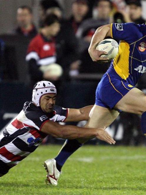 Otago winger Karne Hesketh skips away from the tackle of Counties-Manukau flanker Fritz Lee....